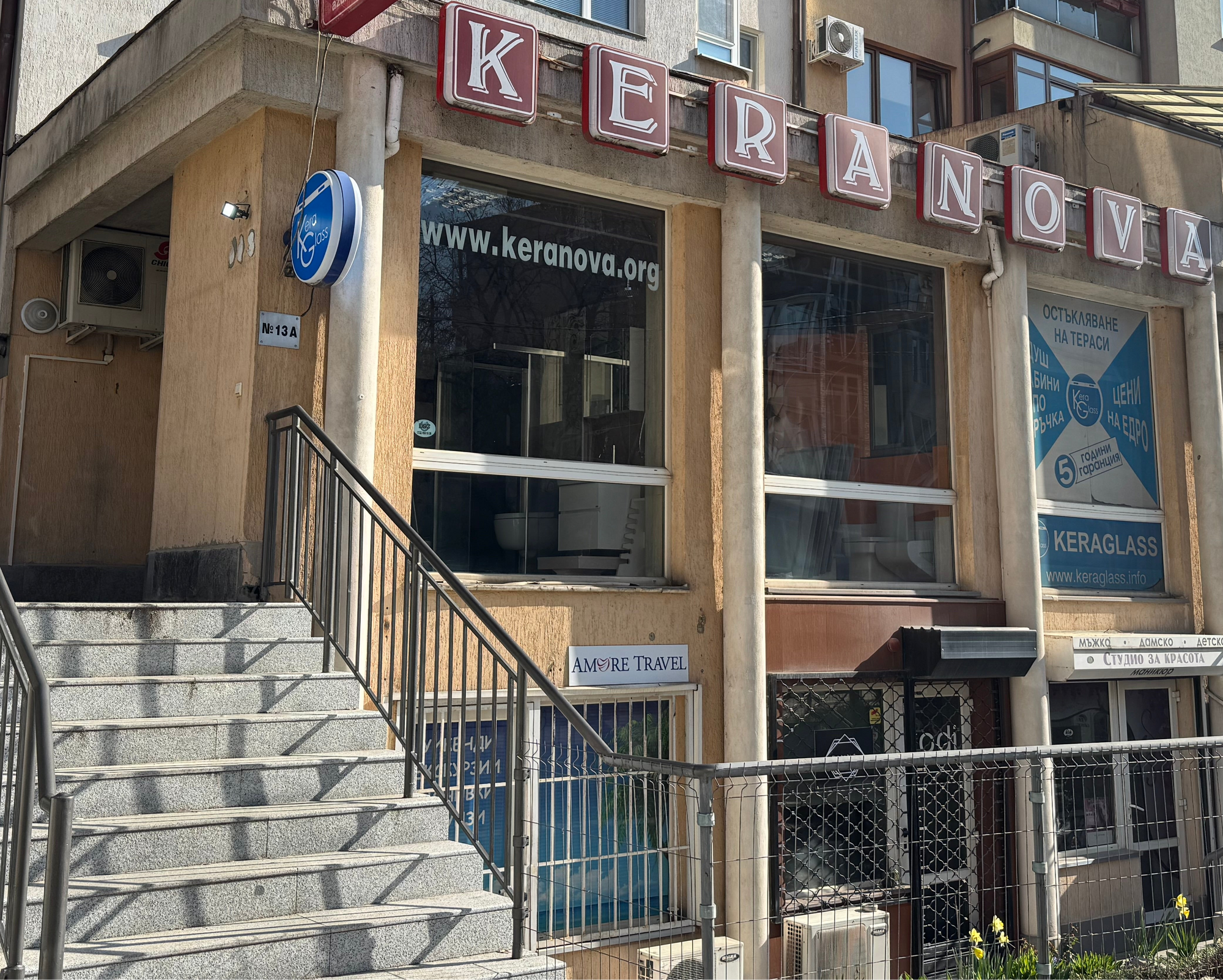 Picture of the Keranova building with visible sign and stairs, showcasing urban architecture and storefronts.