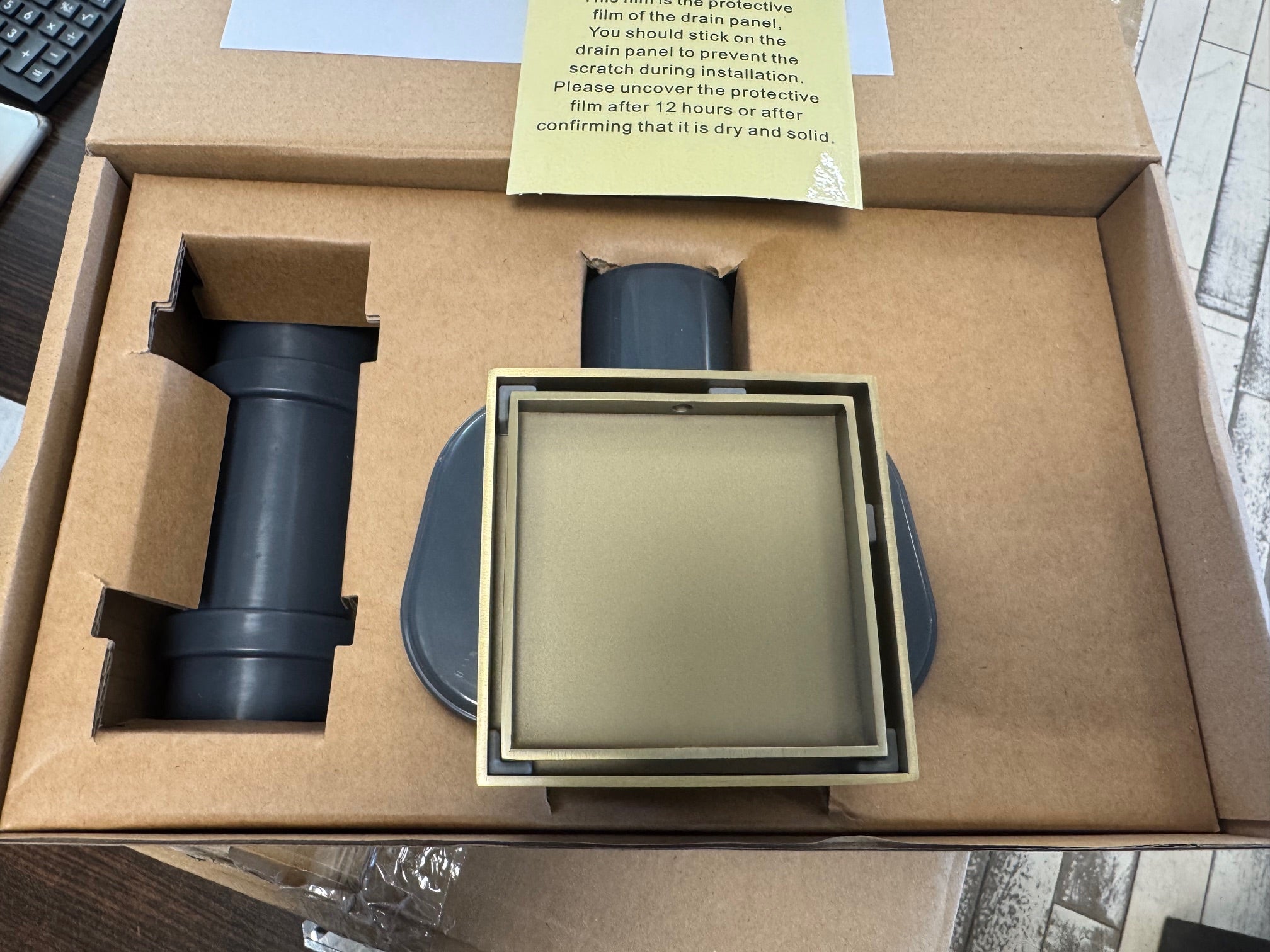 Подов сифон Velora Brushed Gold 10х10 см - драскано злато разопакован с аксесоари и инструкции за монтаж.