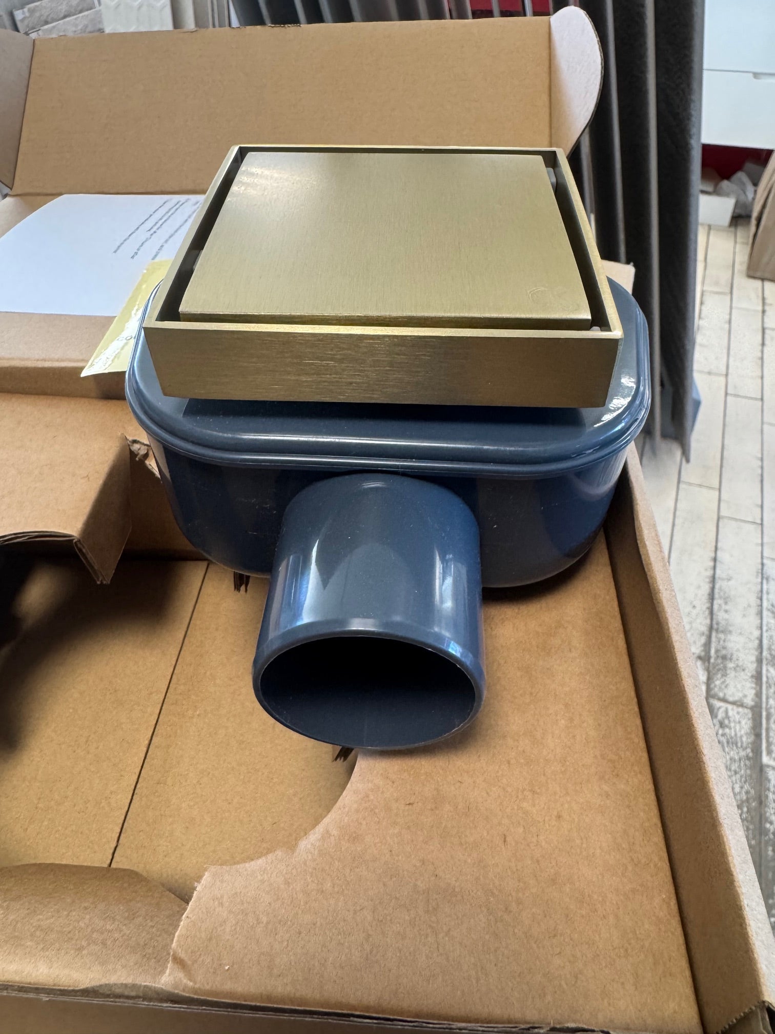 Подов сифон Velora Brushed Gold 10х10 см - драскано злато в опаковка, с неръждаема решетка и страничен изход.