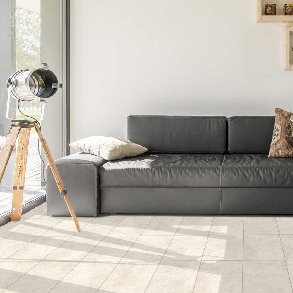 Серия Ark - Qua Granite - 4 цвята, 3 повърхности: светъл кварцов гранитогрес в хол с графитен диван, KERANOVA онлайн магазин
