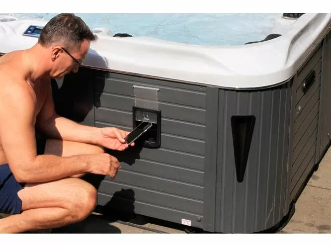 Euphoria MIghty Wave 230x230 см. - мъж поставя телефон в външен държач на СПА модел Euphoria за 4 човека, KERANOVA онлайн магазин